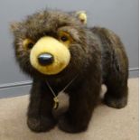 Large sit-on soft toy as a brown bear in a standing pose with faux fur body, inset eyes,