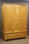 Triple oak wardrobe, three panelled doors enclosing fitted interior above two drawers,