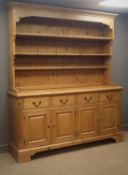 Pine dresser, projecting cornice, dentil frieze, three plate racks, four drawers and cupboard doors,