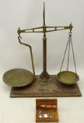 Set of Avery brass balance scales on mahogany base with weights,