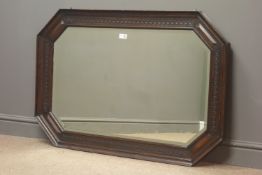 Early 20th century oak bevel edge wall mirror, carved and canted frame, W109cm,