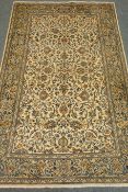 Persian Kashan beige ground rug with floral and foliate field,