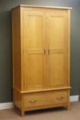 Oak double wardrobe, two panelled doors enclosing fitted interior above single drawer,