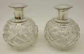 Pair cut glass globular scent bottle with white metal lids stamped Sterling,