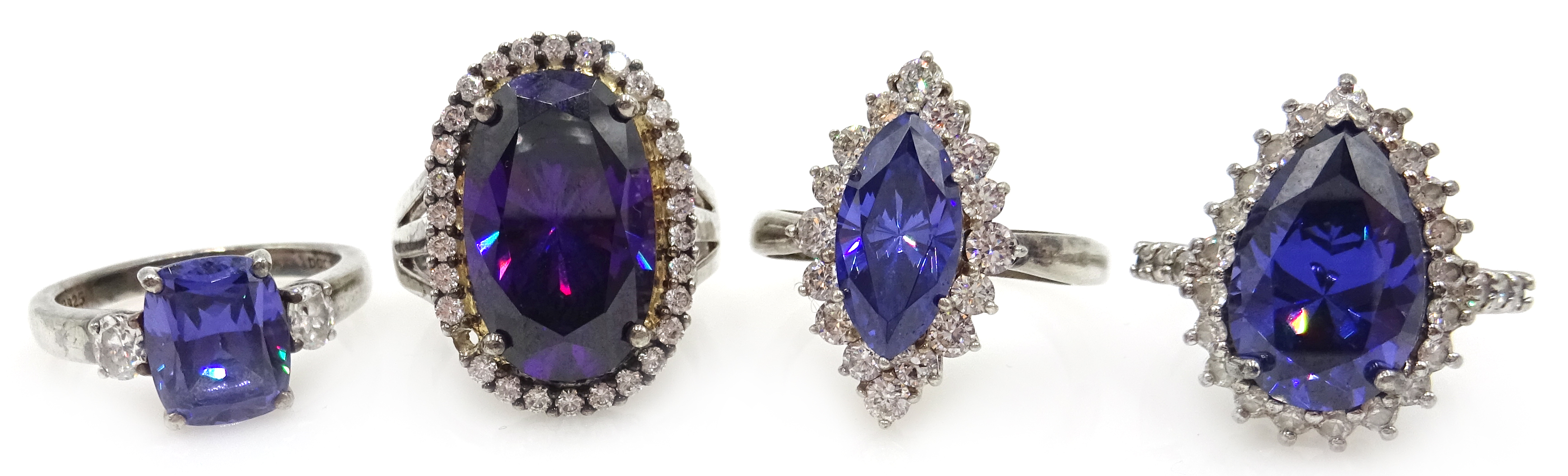 Four silver blue/purple stone and cubic zirconia dress rings,