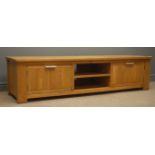 Light oak television stand, centre shelves flanked by two cupboards, stile end supports, W180cm,