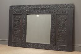 19th century carved oak panel with centre bevel edge mirror plate, decorated with lunettes,