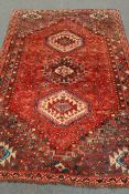 Persian red ground rug, three medallions, floral field,