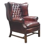 Large 20th century Georgian style wingback armchair, upholstered in buttoned dark brown leather,