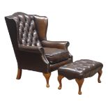 Georgian style wingback armchair and matching stool, upholstered in deeply buttoned brown leather,