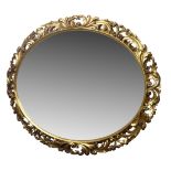 20th century Italian style oval mirror, scrolled leaf gilt wood and gesso frame,