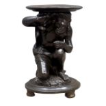 Early 20th century Blackamoor jardiniere stand, the crouching figure supporting a circular top,