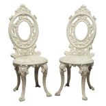 Pair 19th century ornate cast iron garden chairs, oval backs,