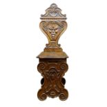 Italian Renaissance style carved walnut hall chair, vase shaped back carved with mask head,