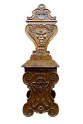 Italian Renaissance style carved walnut hall chair, vase shaped back carved with mask head,