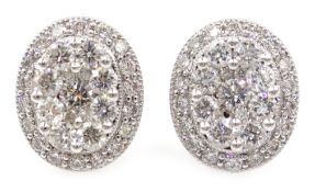 Pair of white gold oval set diamond cluster ear-rings,
