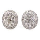 Pair of white gold oval set diamond cluster ear-rings,