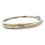 White, yellow and rose gold diamond set cross-over hinged bangle,