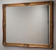 Rectangular wall mirror in swept gilt frame, bevelled glass plate,