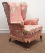 Parker Knoll wingback armchair, upholstered in a pink floral fabric, cabriole feet,
