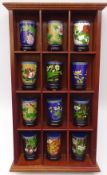 Set of twelve Chinese Cloisonne cylindrical vases on stands, on mahogany wall mounted display shelf,