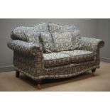 Two seat traditional style sofa floral pattern upholstery with mahogany feet on brass castors,