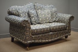 Two seat traditional style sofa floral pattern upholstery with mahogany feet on brass castors,