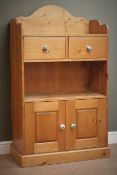 Solid pine open bookcase, raised shaped back, two drawers and cupboard doors, plinth base, W83cm,
