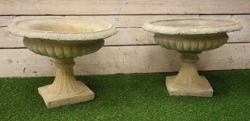 Pair composite stone urn planters, circular form with egg and dart rim and gadroon underside,