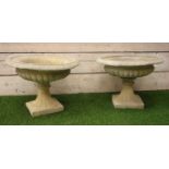 Pair composite stone urn planters, circular form with egg and dart rim and gadroon underside,