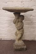 Composite stone shallow circular birdbath held aloft by putto pedestal on stepped base, H83cm,