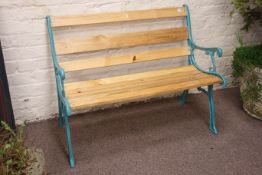 Polished pine slatted garden bench with light blue painted cast iron end supports,