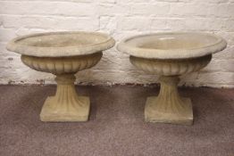 Pair composite stone urn planters, circular form with egg and dart rim and gadroon underside,