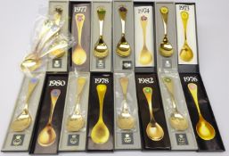 Eleven Georg Jensen silver-gilt Year spoons, 1973 - 1983, each with floral enamelling,
