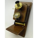 Commemorative wall mounting telephone on wooden backboard with brassed fittings,