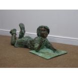 Large bronze sculpture of a boy laid on his front with a pen in his hand, on square base,