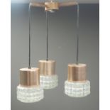 Mid century teak light fitting with three drop down clear glass pendants and copper mounts,