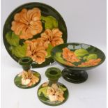 Group of Moorcroft Hibiscus pattern ceramics comprising Comport, H10cm, pair candlesticks and plate,