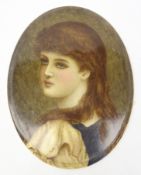 Early 20th century oval porcelain plaque hand painted with a portrait of a young girl signed A. M.