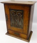 Arts & Crafts oak smokers cabinet with embossed stylized copper panel and fitted interior,