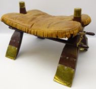 Hardwood camel saddle with fringed leather seat and brass mounts,