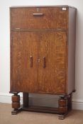 1930s oak cocktail cabinet with hinged fitted compartment above two cupboard doors,