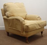 Lounge armchiar, upholstered in a yellow fabric, walnut turned supports on castors,