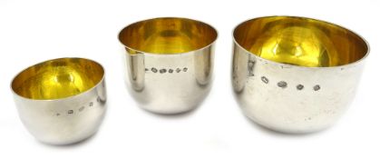 Set of three silver tumbler cups with gilt interiors by J A Campbell London 2001, diameter 7.
