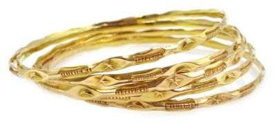 Five Middle Eastern 18ct gold (tested) bangles,
