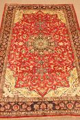 Nafaf Abad red ground rug, central medallion on floral field, repeating border,