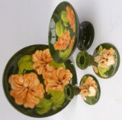 Group of Moorcroft Hibiscus pattern ceramics comprising Comport, H10cm, pair candlesticks and plate,