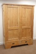 Continental pine double wardrobe, projecting corncie, two panelled doors enclosing hanging rail,