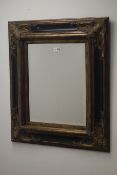 Gilt and black moulded cushion framed bevel edge mirror, W68cm,