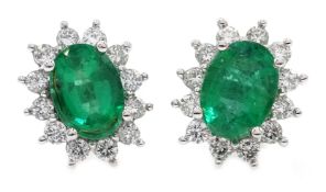Pair of white gold emerald and diamond cluster stud earrings,